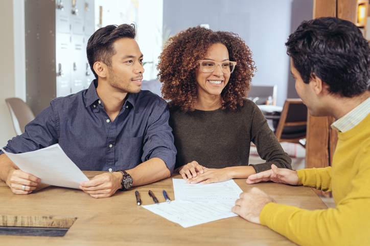 Couple comparing mortgage interest rates with a financial advisor.