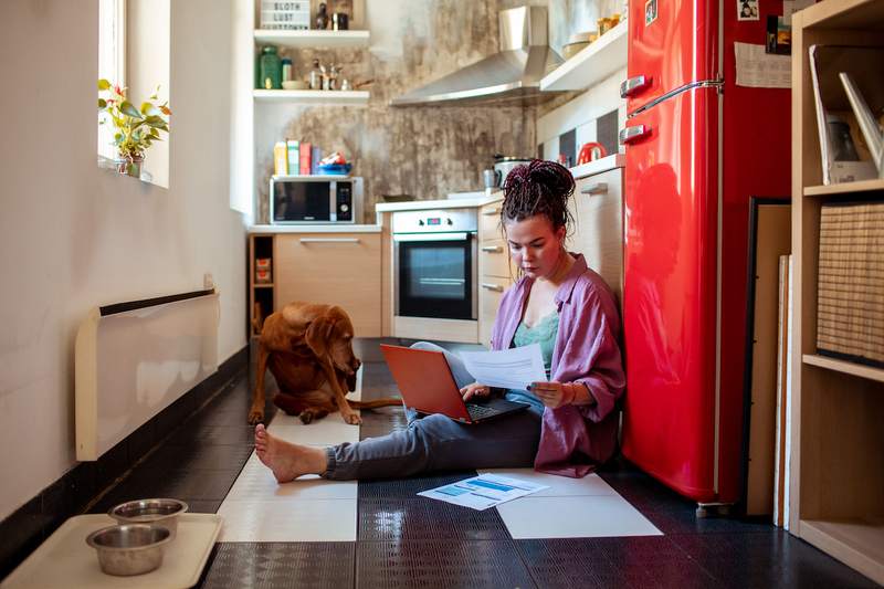 Women with dog in kitchen reviews her finances.