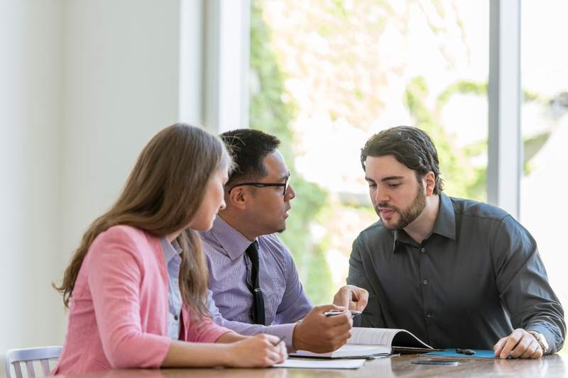 Couple looks at their monthly mortgage payment with lender.