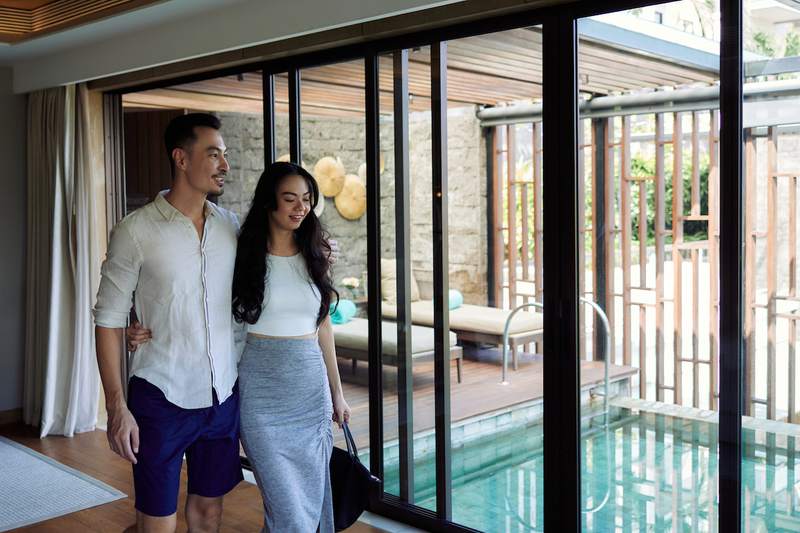 Couple tours a home with a pool.
