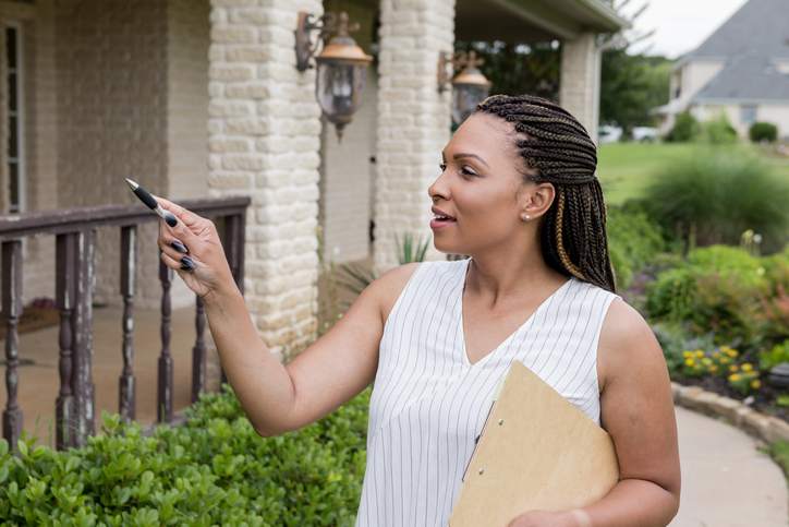 A home appraiser examines the exterior of a property.