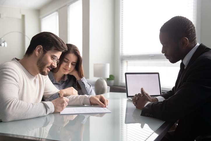 Couple reviewing their house closing costs with a mortgage loan officer