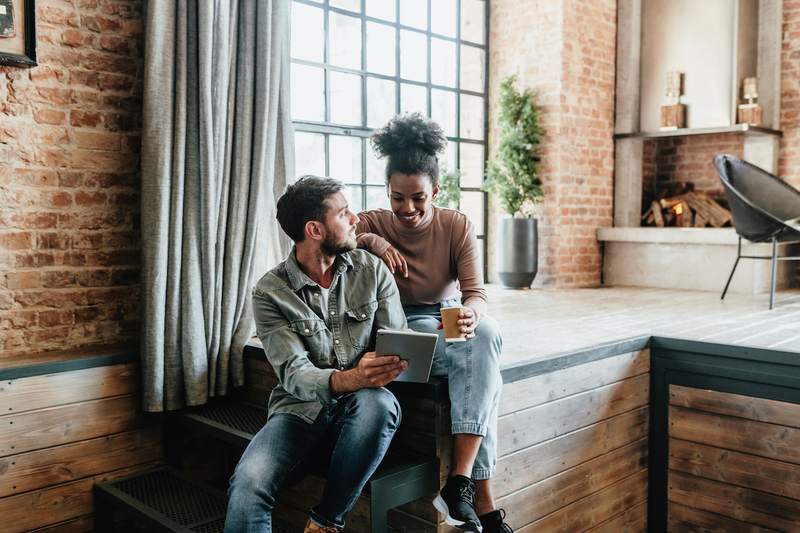 Couple uses a laptop in a loft apartment.