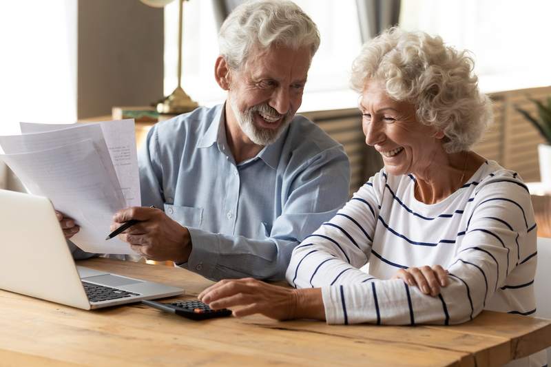 Older couple makes a reverse mortgage payment online.