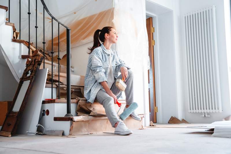 A woman rests on stairs while building a new home.