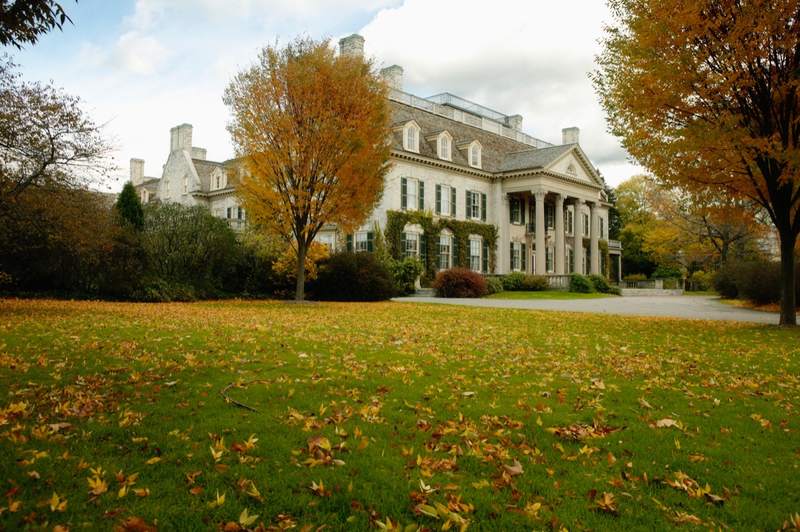 Leaves fall on the front yard of a beautiful mansion.