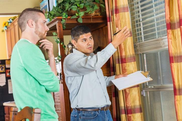 Homeowner and home inspector examine a house's interior window