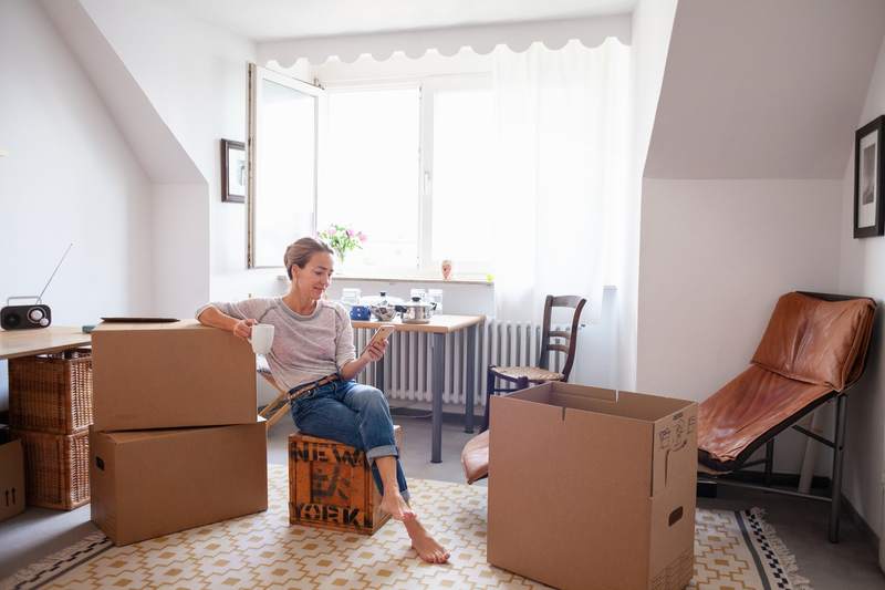 Resident unpacks after purchasing a small house.