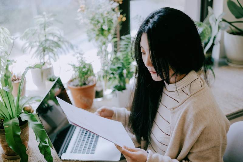 A woman reviews title search results while working at a computer.