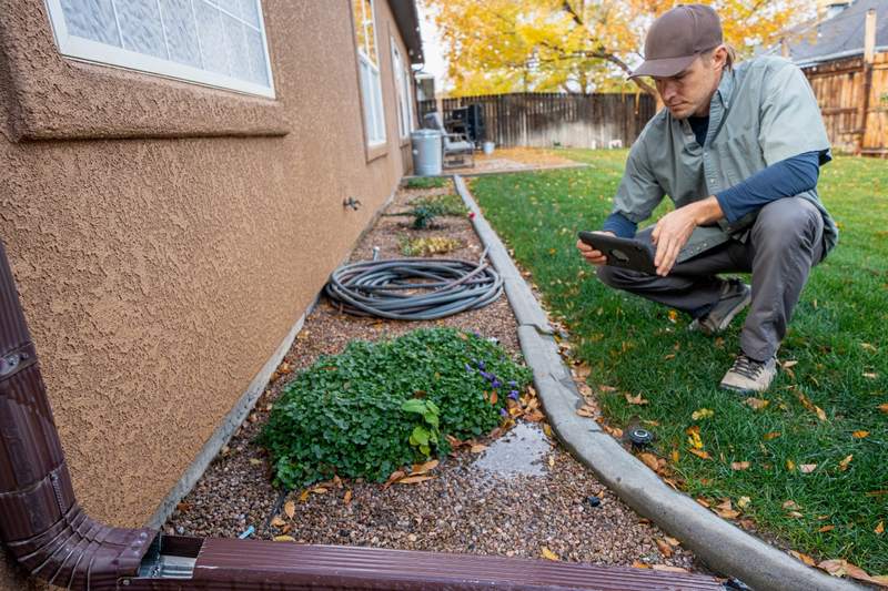 A home inspector checks the exterior of a house.