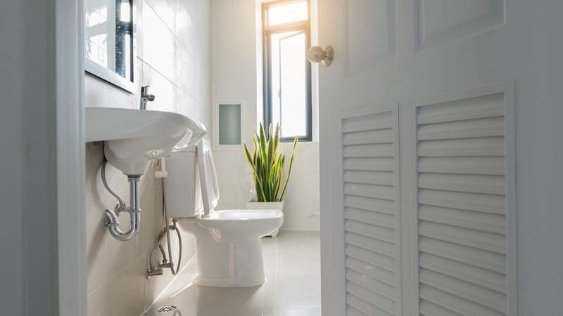 A door opens revealing a newly renovated half bath.