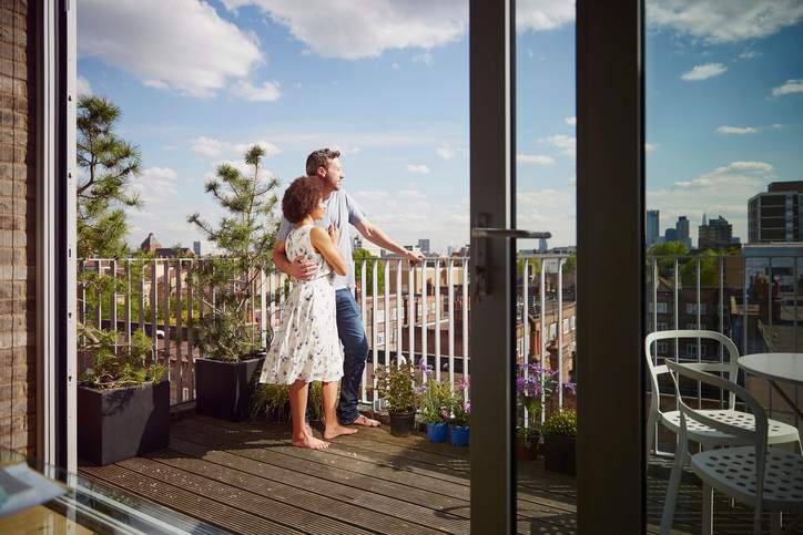 A couple stands on a condo balcony.