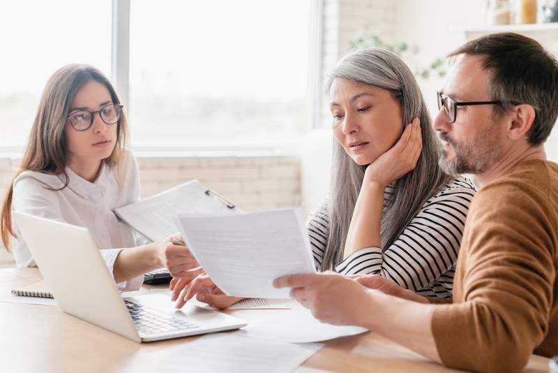 Escrow agent meets with couple buying home.