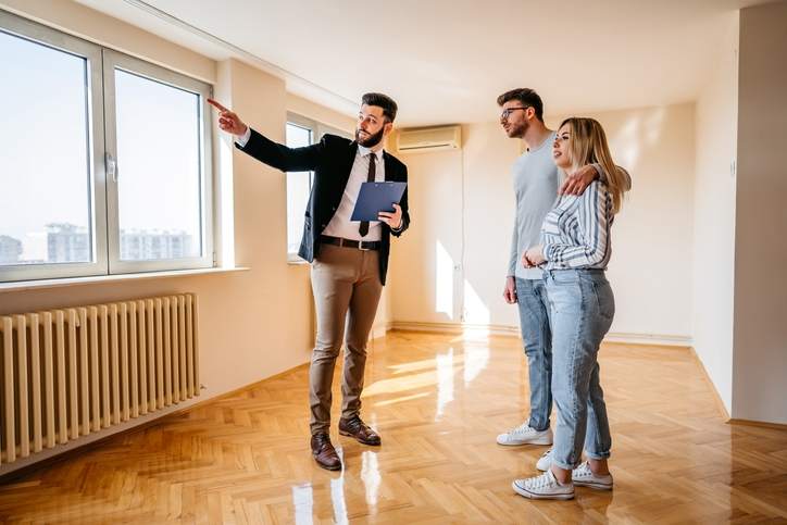 Real estate agent shows couple a condo and explains the house closing process.