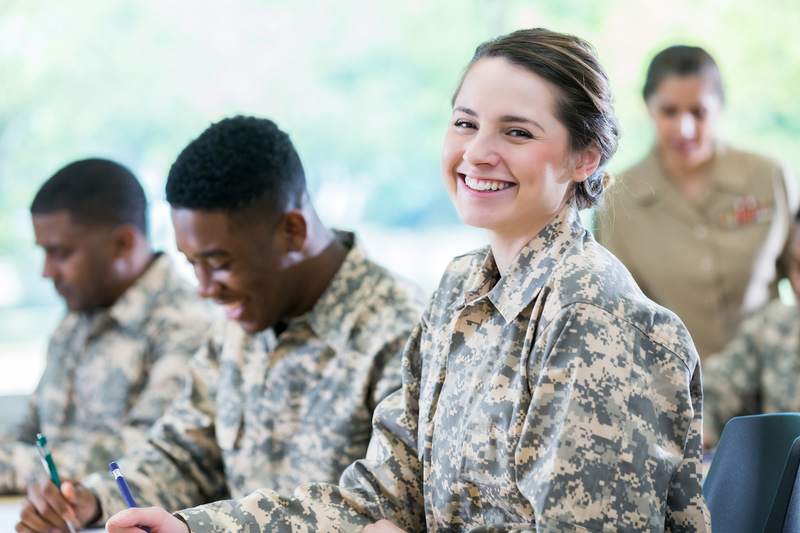 Soldier smiles in classroom of cadets.
