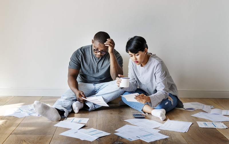 Homeowner couple overwhelmed by bills.