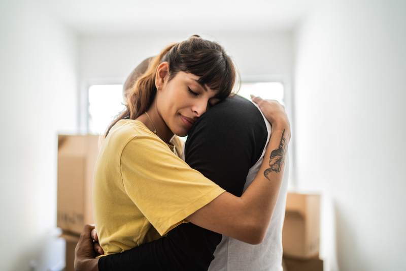 A woman and man embrace to take comfort as they face foreclosure.