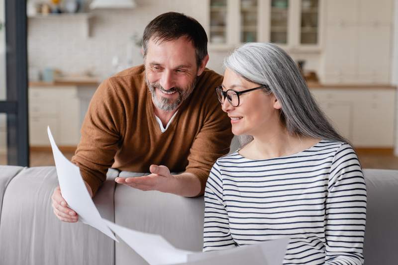 Smiling couple reviews financial documents.