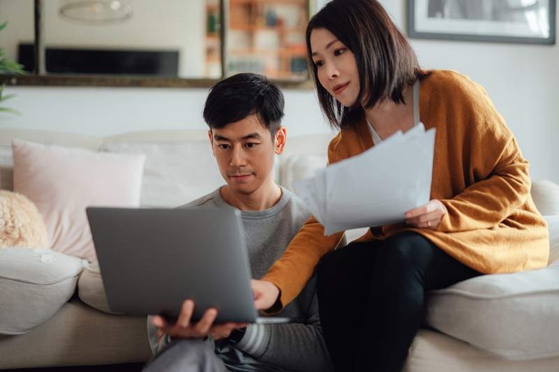 A couple compares mortgage offers together at home.