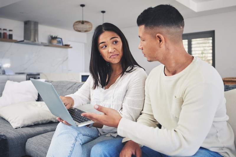 A couple sits on a sofa considering loan options.