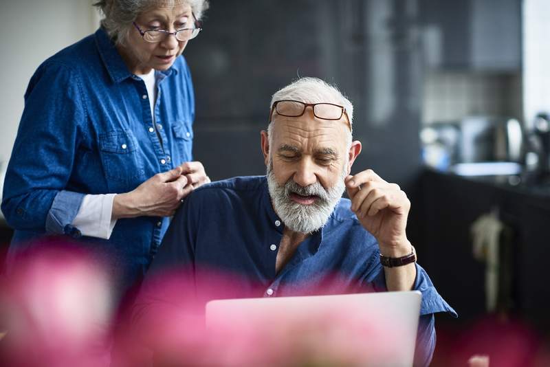 Older couple learns about reverse mortgages on a laptop in their home.