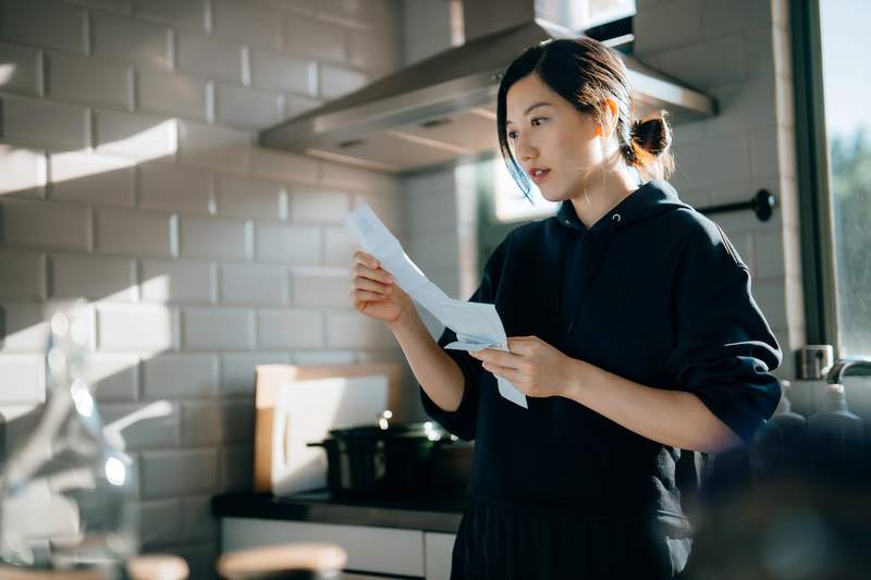 A woman in a kitchen compares appraisal costs.